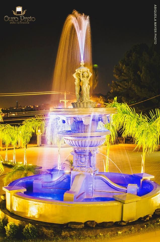 Fonte iluminada à noite com estátuas